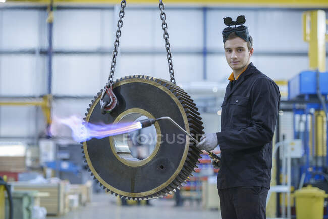 Portrait of engineer heat treating industrial gear in factory — Stock Photo