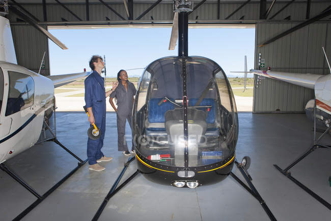 Pilotos estudiantes revisando exterior del helicóptero - foto de stock