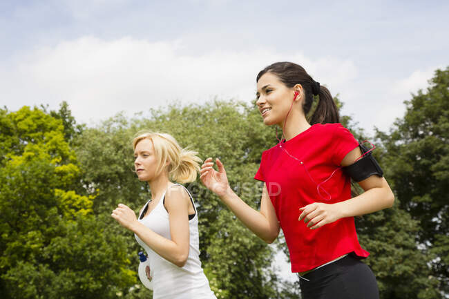 Femmes jogging à travers le parc — Photo de stock