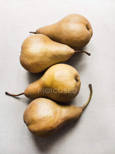 Top view of Four Bosc pears on white tabletop — Stock Photo