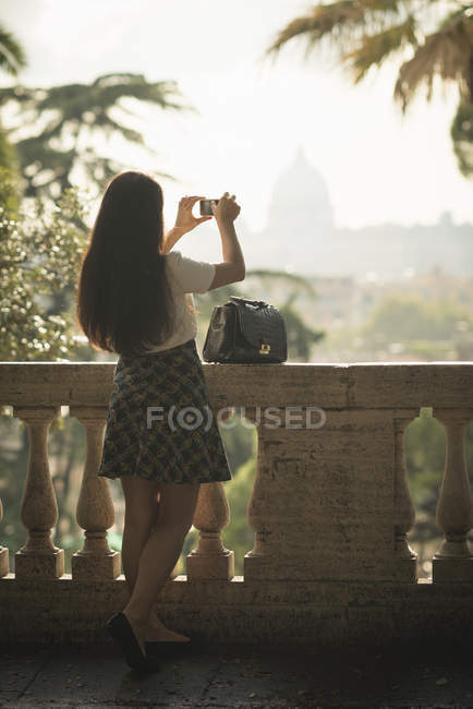 Mujer tomando fotos con teléfono móvil, Pincio Gardens, Villa Borghese, Roma - foto de stock