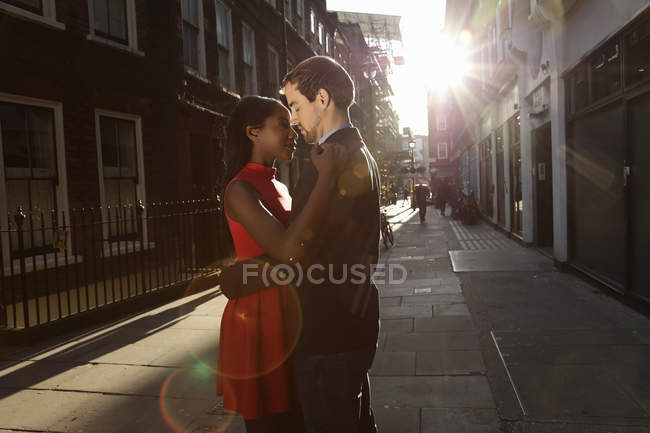 Casal de pé juntos na rua, cara a cara, abraçando — Fotografia de Stock