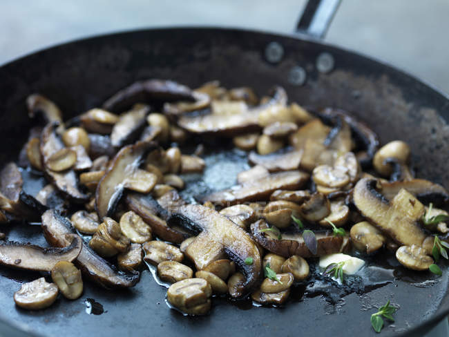 Funghi che friggono nel burro in padella, primo piano — Foto stock