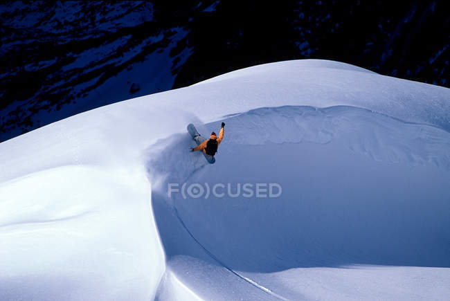 Snowboarder girando em torno de um banco de neve — Fotografia de Stock
