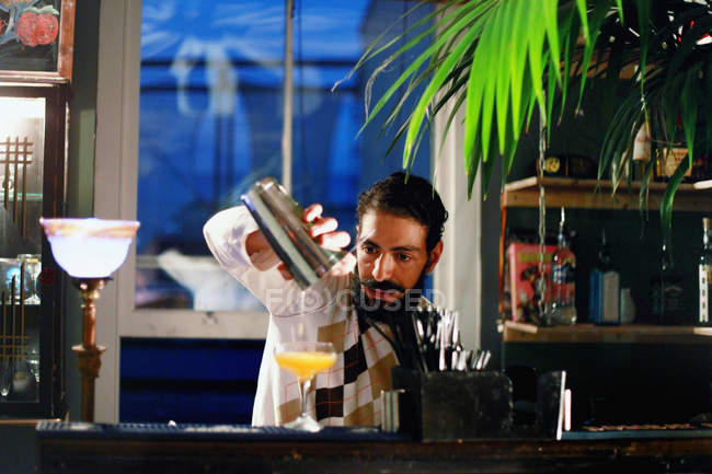 Male bartender serving cocktail at bar — Stock Photo