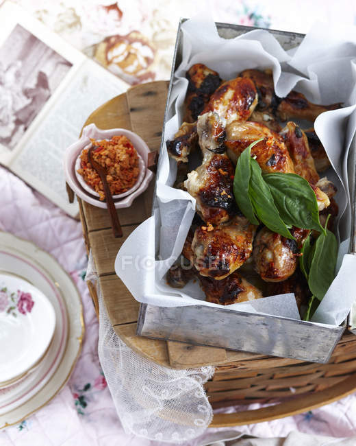 Top view of chicken legs with citrus chilli salt and basil — Stock Photo