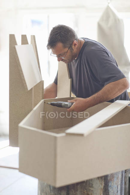 Polsterer bohrt Möbelkastengestell — Stockfoto