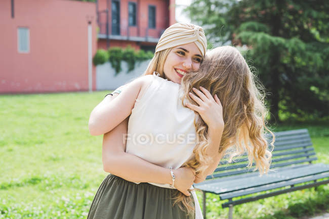 Amici felici che si abbracciano nel parco insieme — Foto stock