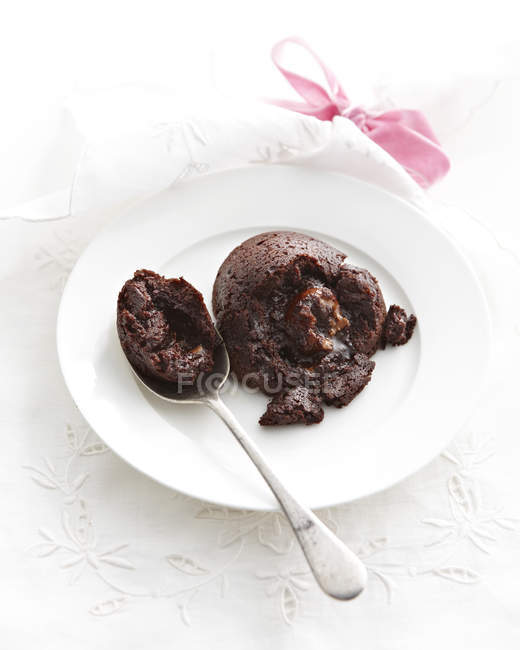 Piatto con torta di lava al cioccolato rotto con cucchiaio — Foto stock