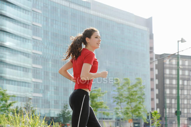 Молода жінка біжить у місті — стокове фото