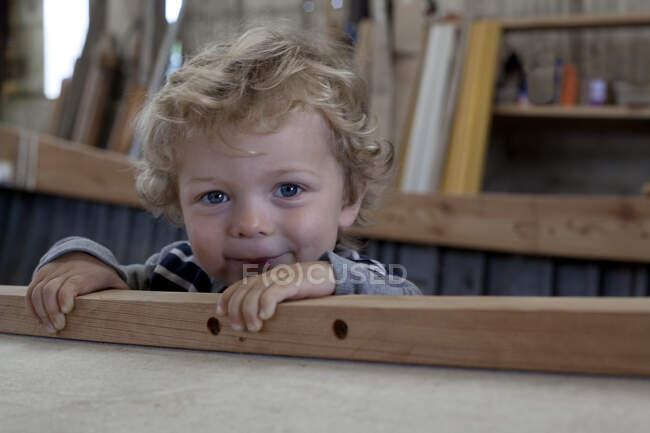 Close up portrait of male toddler inside boat in workshop — Stock Photo