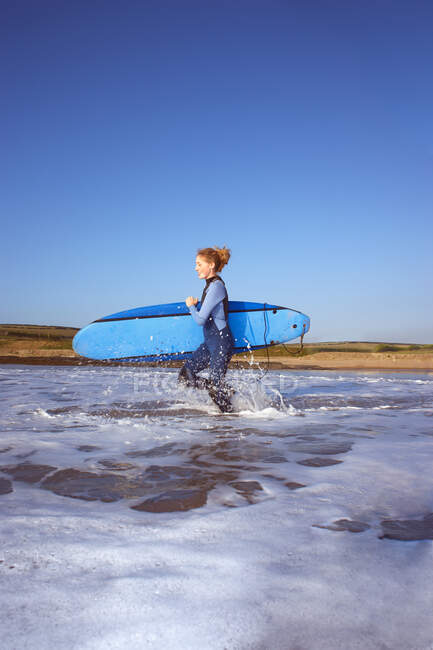 Жінка-серфер біжить у воду — стокове фото