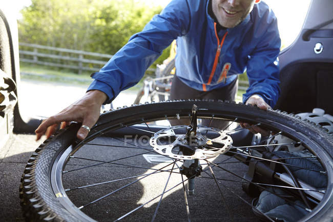Ciclista quitando bicicleta del maletero del coche - foto de stock