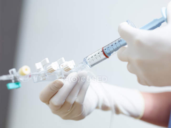 Cropped image of male surgeon administering syringe — Stock Photo