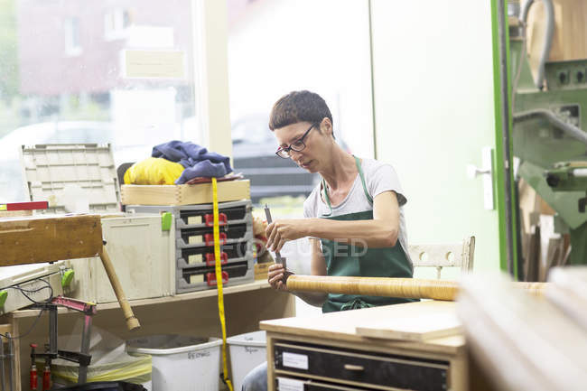 Frau in Werkstatt bastelt Alphorn — Stockfoto