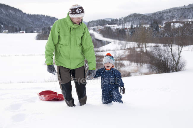 Vater und Sohn spielen im verschneiten Feld — Stockfoto