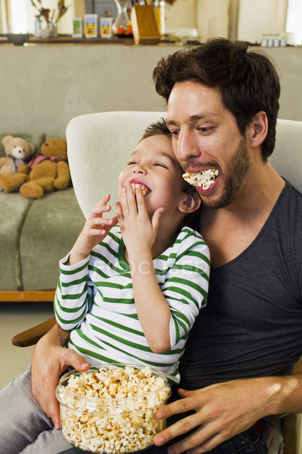 Father and little son with mouthfuls of popcorn — Stock Photo