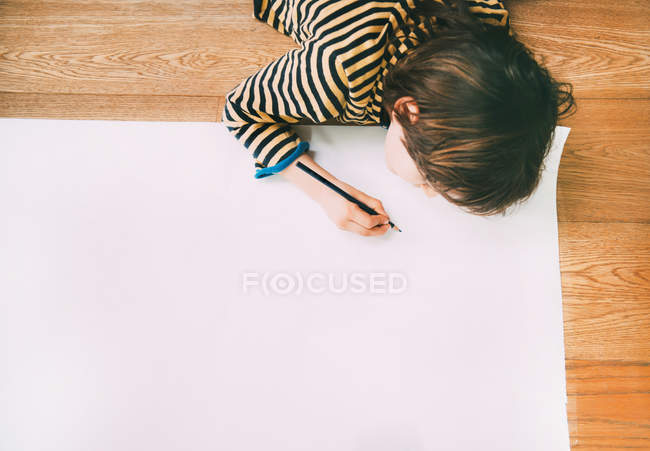 Overhead-Ansicht des Jungen Zeichnung auf großem Papier auf dem Boden — Stockfoto