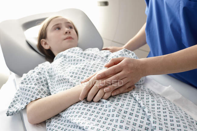Fille d'âge élémentaire entrant dans CT scanner et tenant la main avec une infirmière — Photo de stock