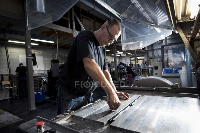 Arbeiter wartet Druckmaschine in Druckerei — Stockfoto