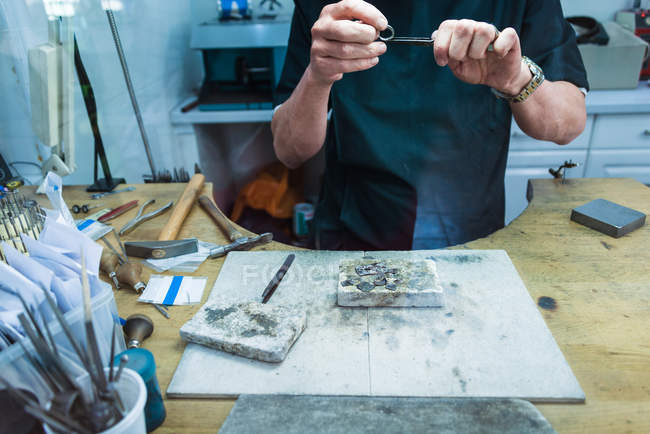 Обрезанный кадр ювелирного мастера, подающего платиновое кольцо — стоковое фото