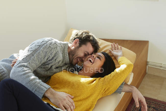 Mid adult couple on window seat face to face laughing — Stock Photo