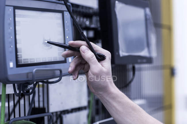 Mano del ingeniero usando el lápiz óptico en la pantalla en fábrica - foto de stock