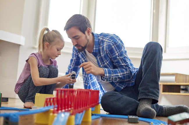 Vater und Tochter spielen mit Spielzeugeisenbahnset — Stockfoto