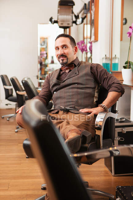 Portrait of mature male hairdresser in hair salon — Stock Photo