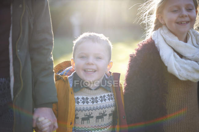 Siblings enjoying sun in garden together during cold weather — Stock Photo