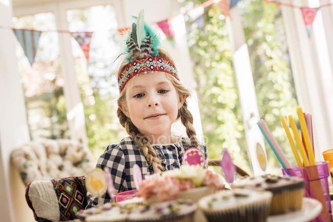 Menina olhando para cupcakes em crianças festa de aniversário — Fotografia de Stock