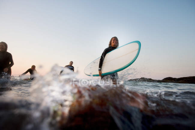Vier Personen mit Surfbrettern im Wasser — Stockfoto