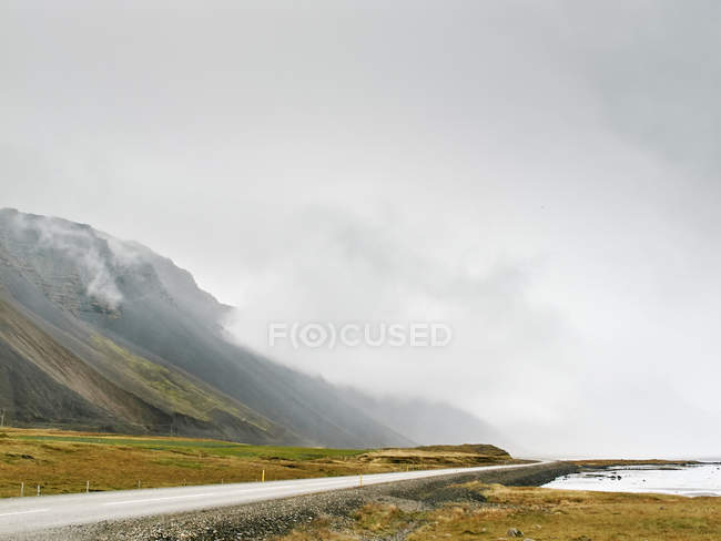 Nube baja en la ladera de la montaña, Hof, Islandia - foto de stock