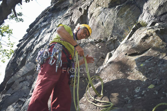 Vista a basso angolo dell'arrampicatore che prepara la corda da arrampicata — Foto stock