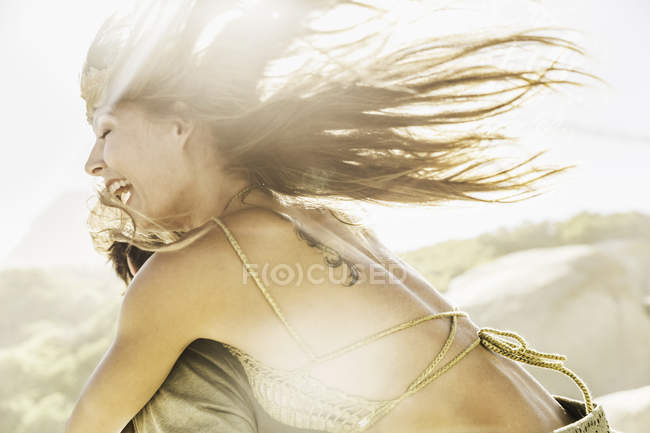 Woman getting running piggy back on sunlit beach, Ciudad del Cabo, Sudáfrica - foto de stock