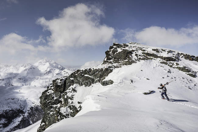 Mid adult male skier walking to top of mountain with skis, Corvatsch, Switzerland — Stock Photo