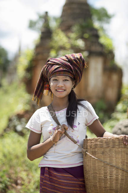 Chica adolescente con pañuelo en la cabeza que lleva la cesta, lago Inle, Birmania - foto de stock