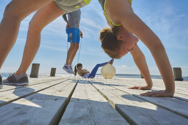 Friends on pier using exercise equipment — Stock Photo
