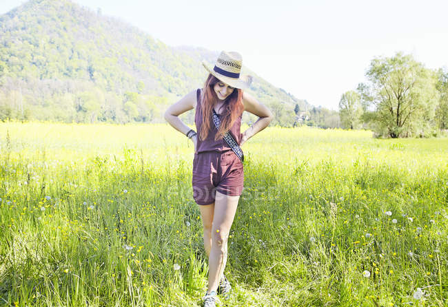 Young woman standing in green summer field — Stock Photo