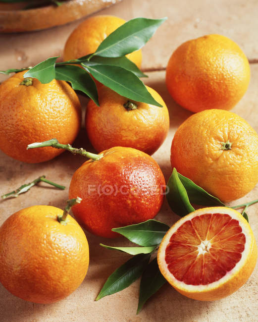 Свіжі кров'яні апельсини з листям, крупним планом — стокове фото