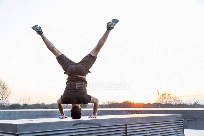 Homme adulte moyen équilibrant sur la tête, en position yoga, vue arrière — Photo de stock