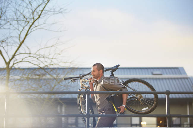 Бізнесмен працює з велосипедом і текою в руках — стокове фото