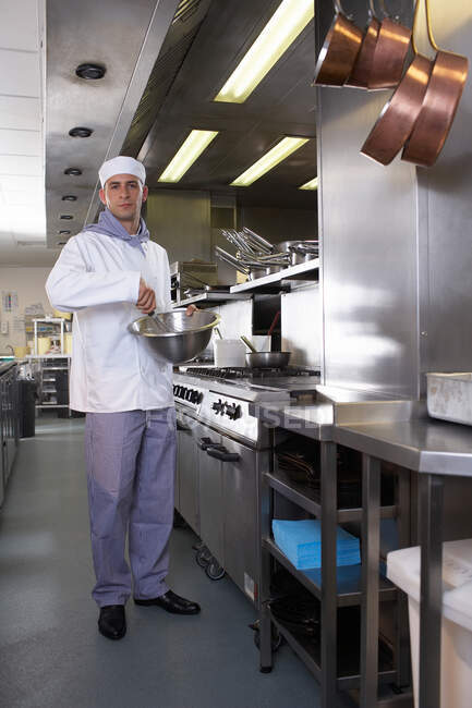 Koch schlägt Essen in Schüssel in Küche — Stockfoto