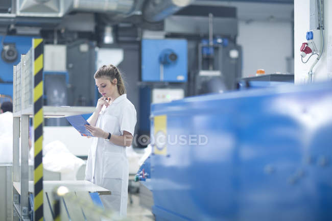 Woman working at machinery in laundry — Stock Photo