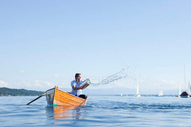 Throwing buckets of water ot ouf boat — Stock Photo