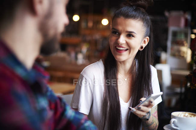 Couple with smartphone in cafe — Stock Photo