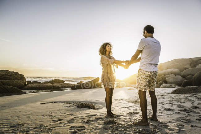Couple profitant de la plage au coucher du soleil — Photo de stock