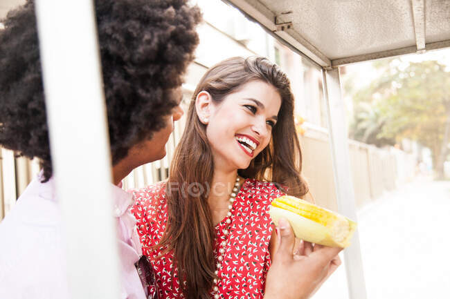 Pareja joven tomando snack de maíz dulce - foto de stock