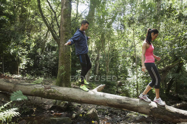 Giovani joggers bilanciamento sul tronco d'albero — Foto stock