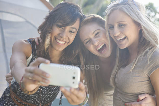 Three young female friends taking a selfie with smartphone — Stock Photo